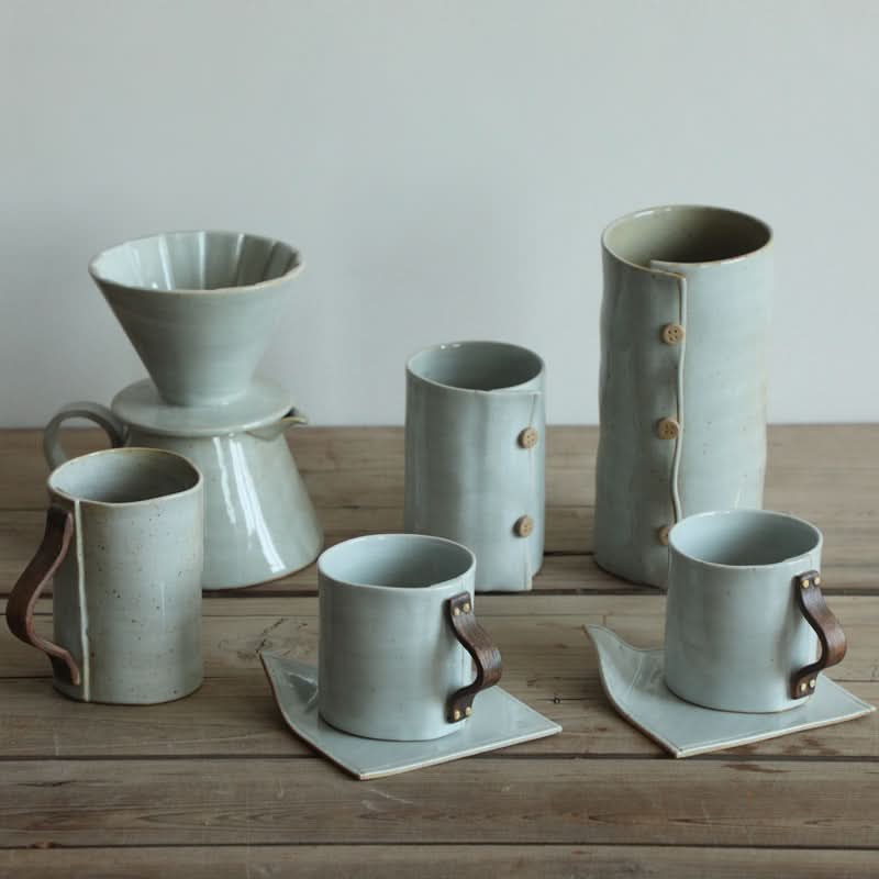 Grey textile-folded ceramic cups, coffee mug, and brewer set.