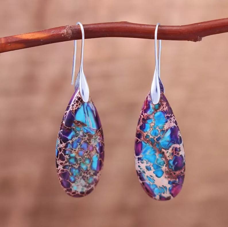 Teardrop Stone Earrings: Colorful purple & blue stones with silver setting hanging from branch.