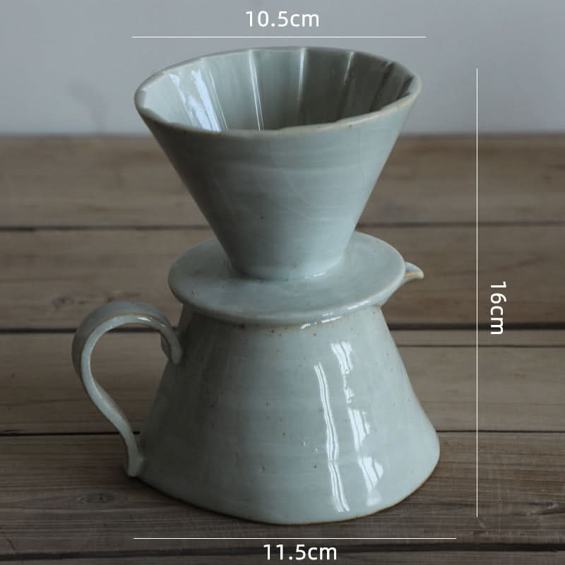 Grey ceramic coffee brewer, textile folded style, on wooden surface.
