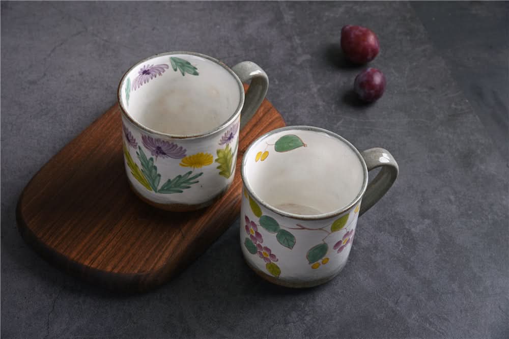 Japanese Underglaze Ceramic Flower Mugs hand-painted with purple, yellow flowers on a wooden board.