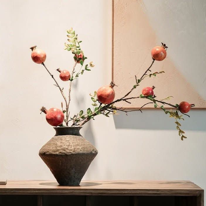 Abstract geometric ceramic vase with hammered texture, home decor, with pomegranate branches.