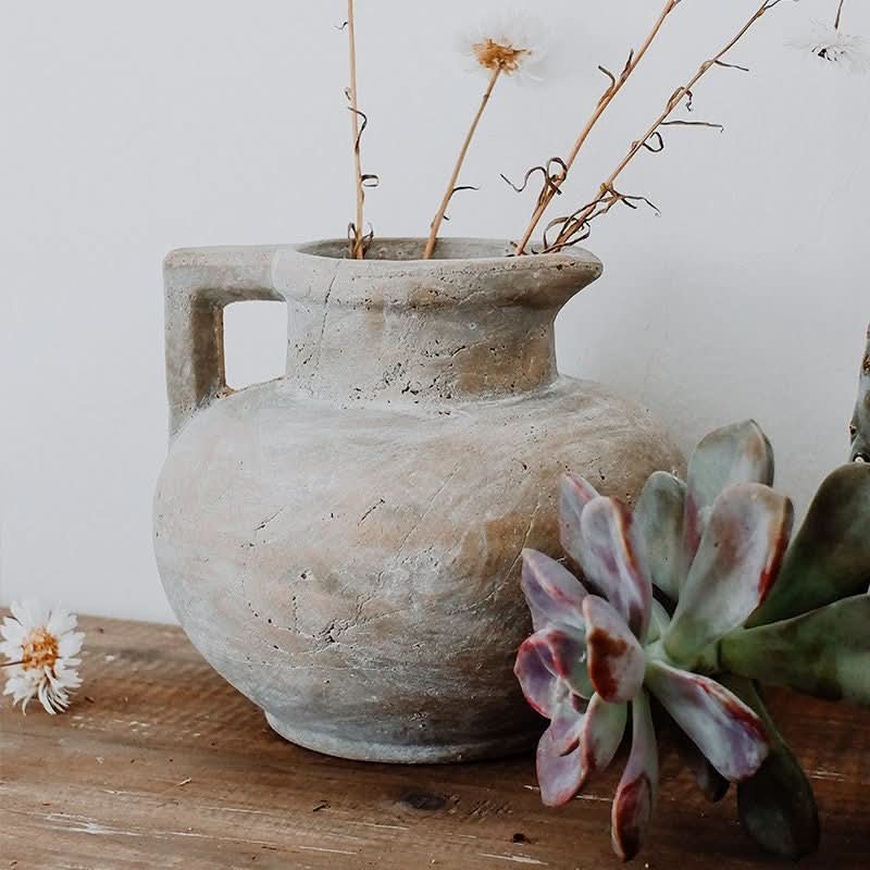 Distressed clay pot with handle, holding dried flowers & succulents. Antique style home decor.