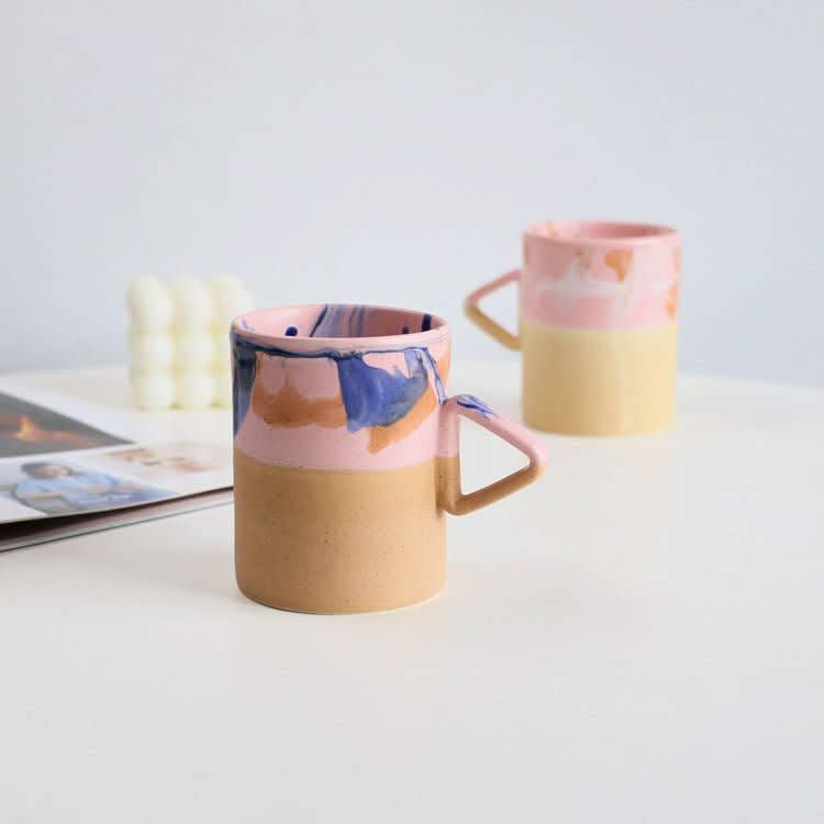 Artistic Triangle Handle Stoneware Mug: pink, blue, tan glaze on ceramic.