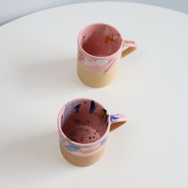 Artistic Triangle Handle Stoneware Mugs in pink and beige with abstract splatter glaze.
