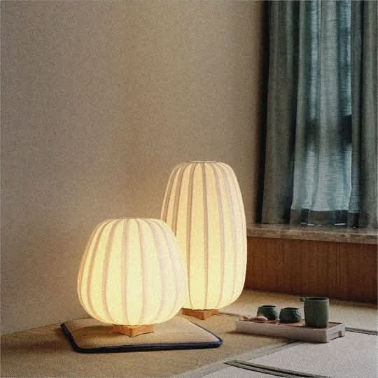 Japandi Table Lamp with oval shape, off-white fabric shade, wooden base, warm glow.