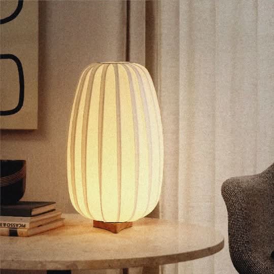 Japandi Table Lamp With Oval Shape: Soft white oval lamp with vertical ribbed texture on wooden base.