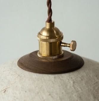 Textured paper mache lamp shade with brass fixture and wood base.