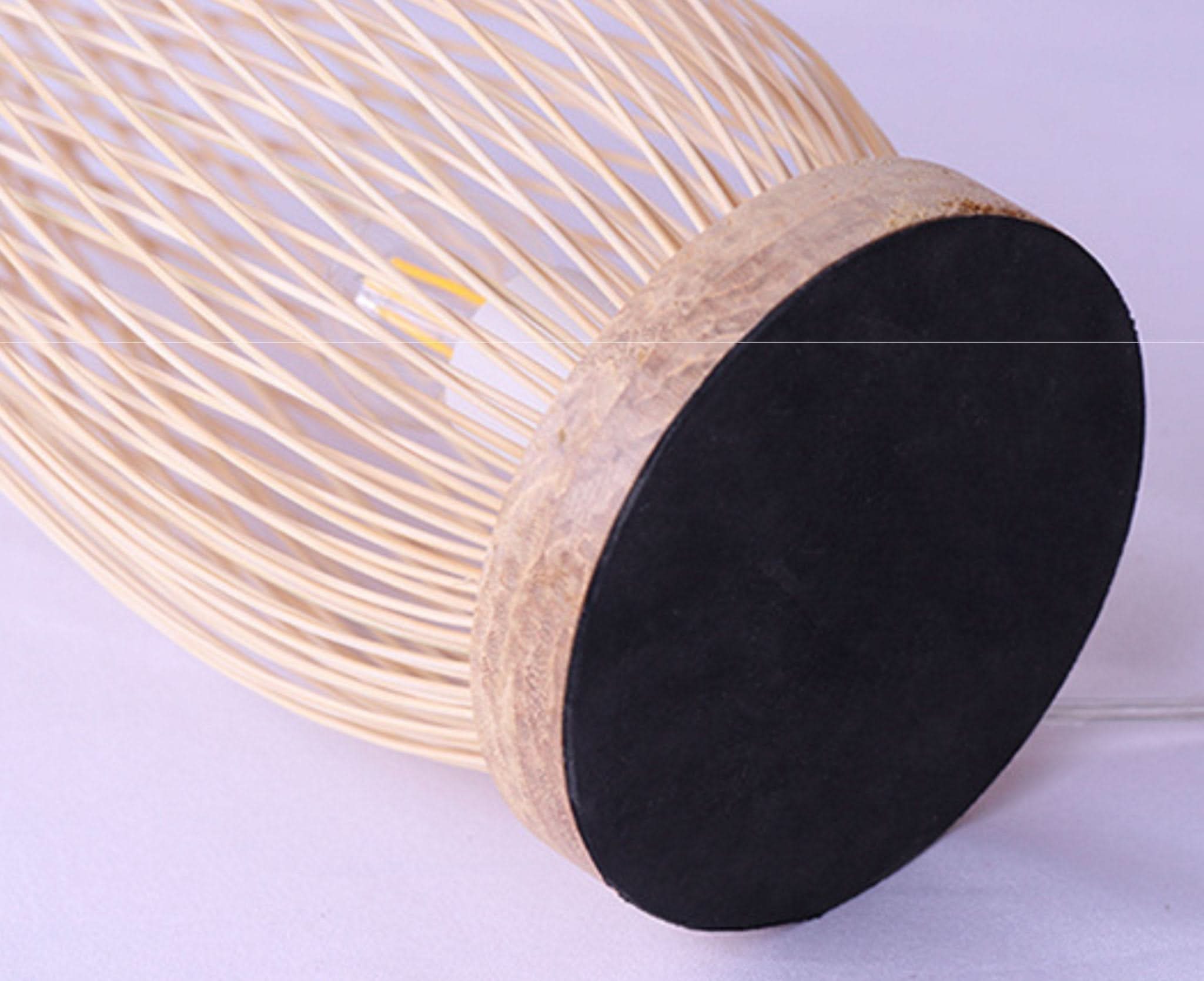 Natural rattan table lamp with a wooden base and black handle accent.