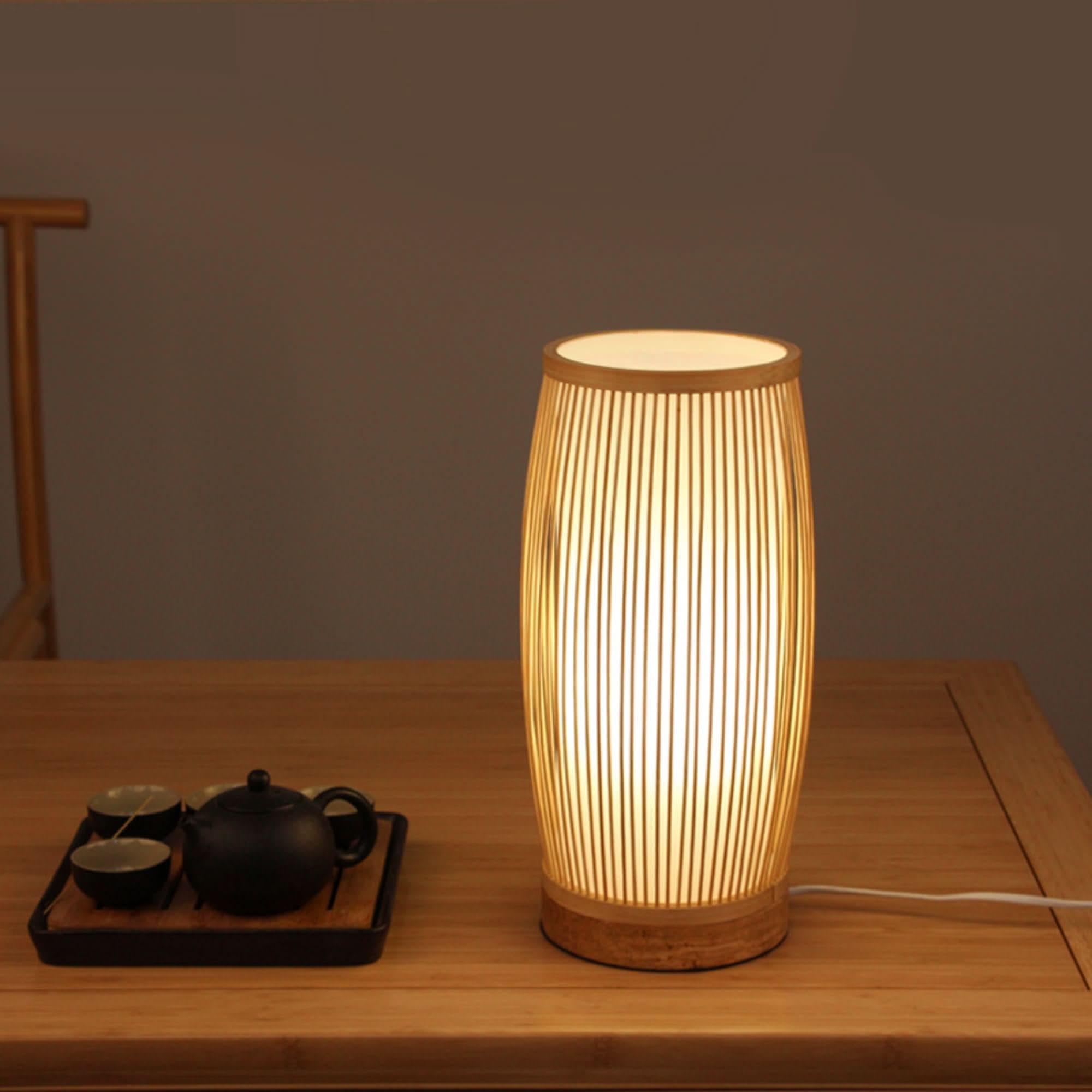 Bamboo Rattan Vertical Floor Lamp with wicker lampshade on a wooden table.