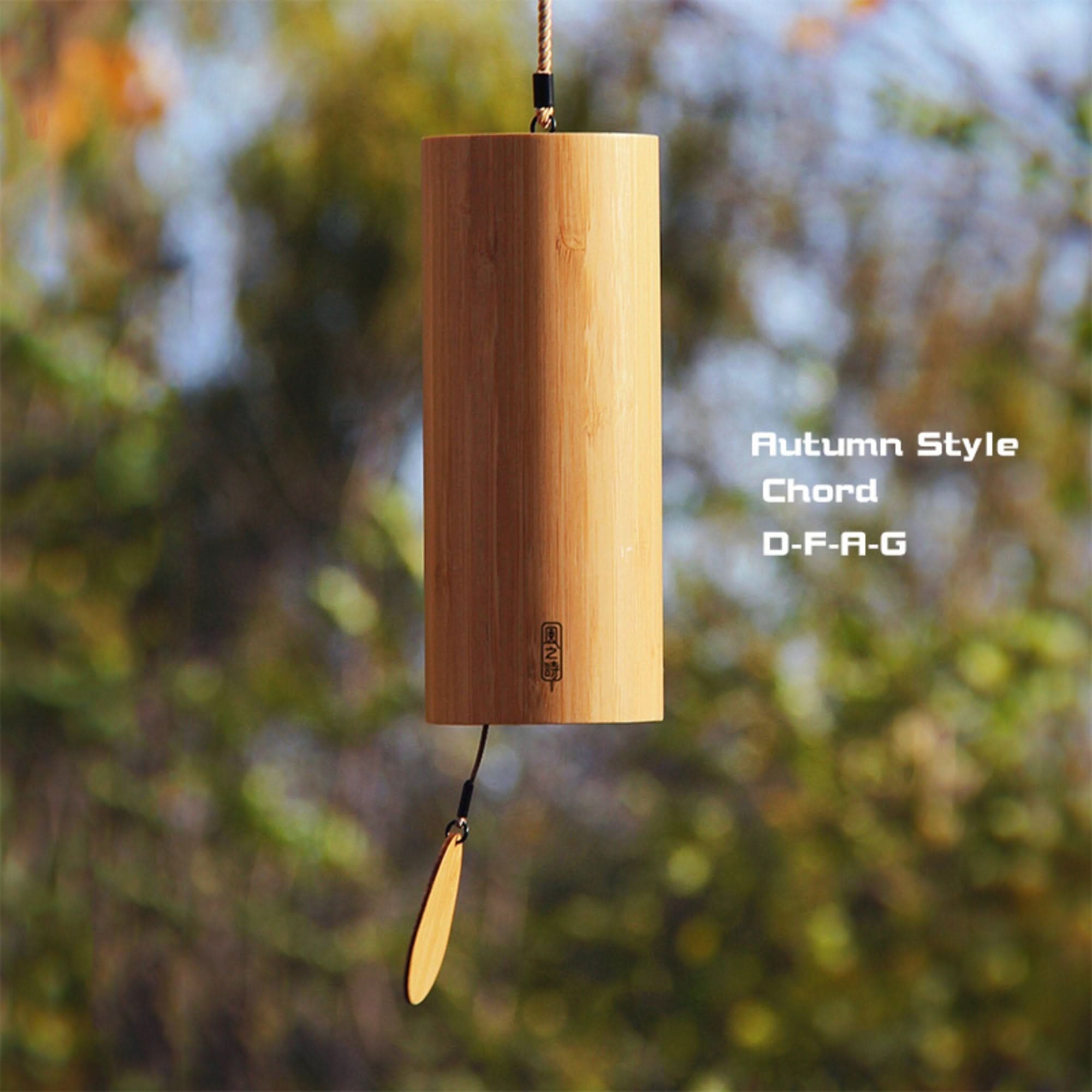 Bamboo wind chime with 4 melodies, natural wood, hangs outdoors in fall foliage.