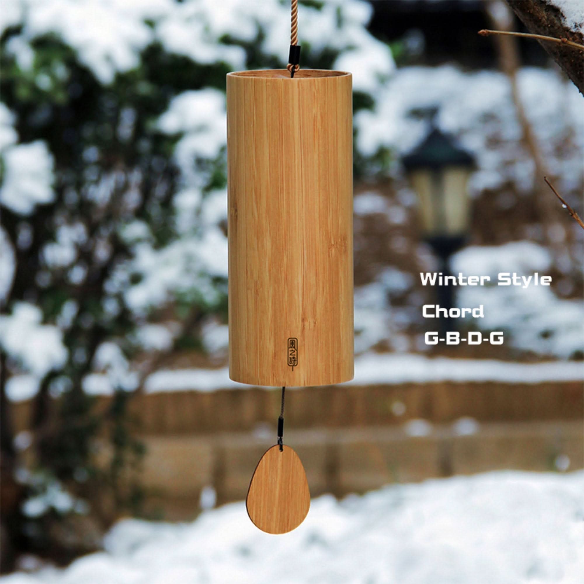 Natural bamboo wind chime with 4 melodies, hanging outdoors in the snow.