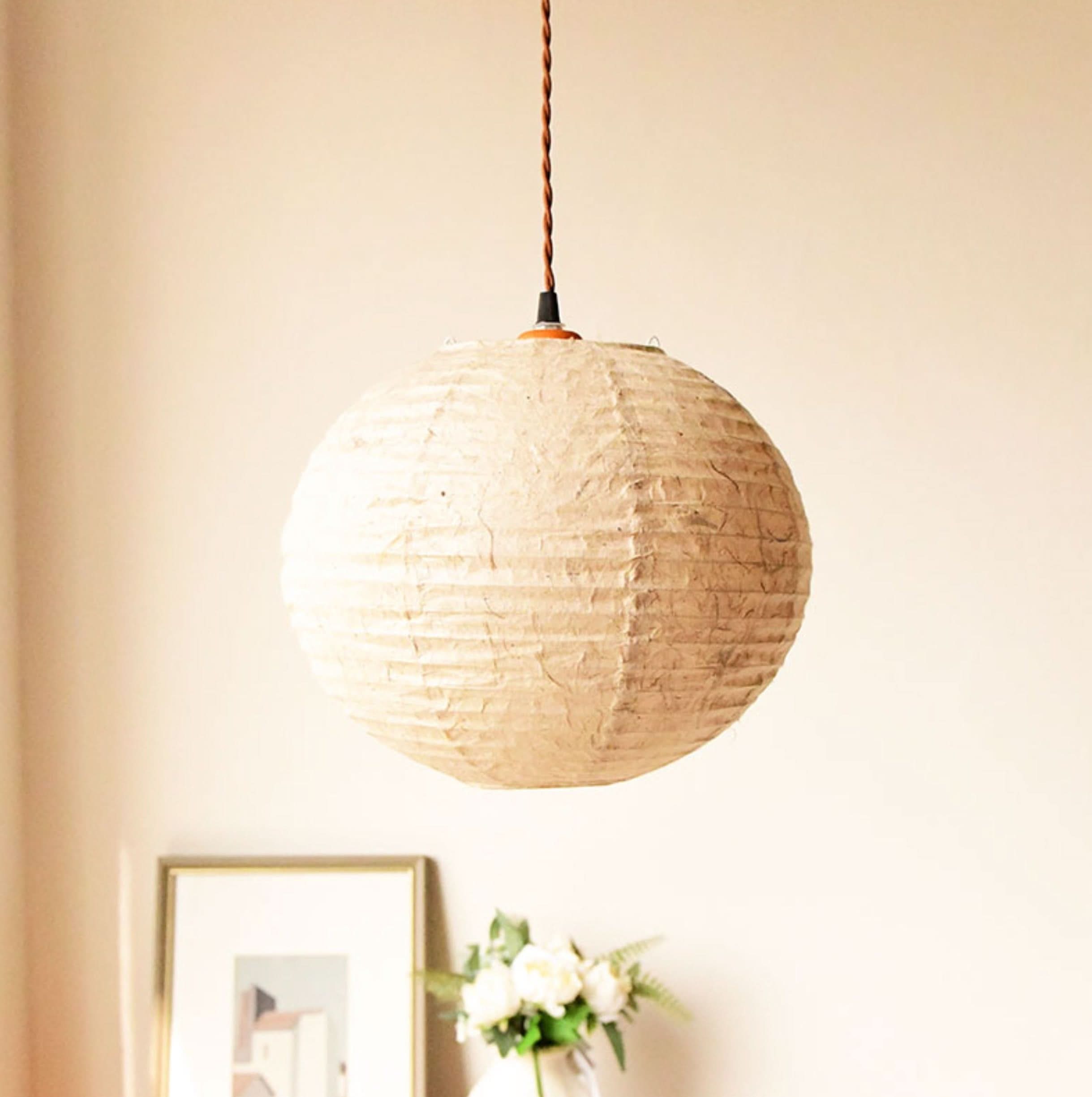 Natural paper lampshade in a warm, textured style, perfect for home decor.