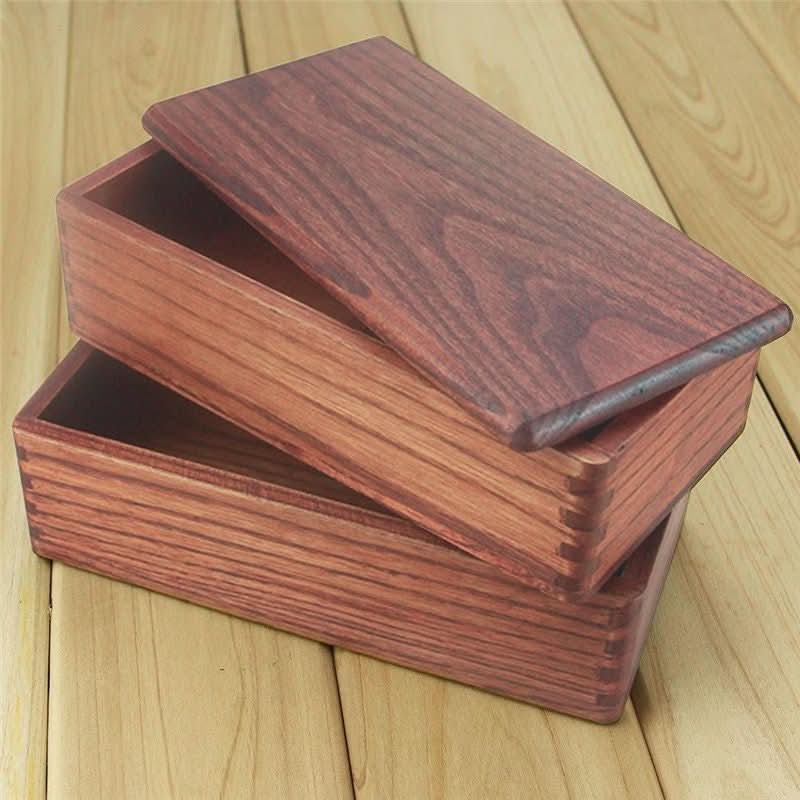 Rich brown wooden bento food box 7.0"x3.9"/18x10cm on a wooden surface.