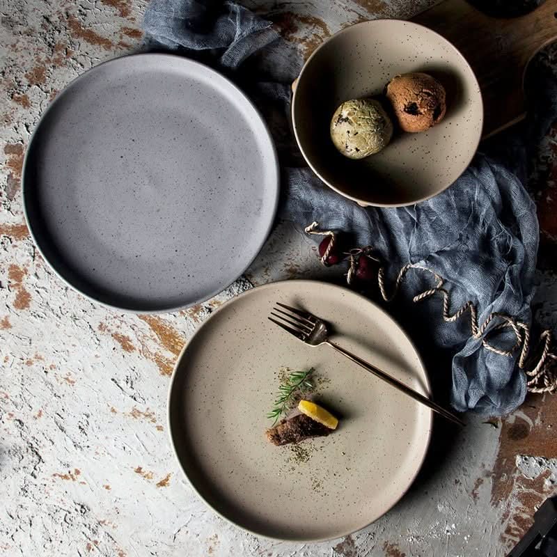 Grey and beige ceramic Nordic plates from Bistro Ceramic Tableware, with fork and food.