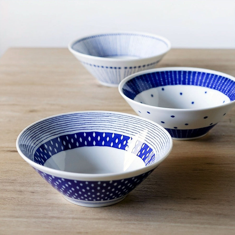 Blue and white patterned ceramic Japanese ramen bowls on a wooden table.