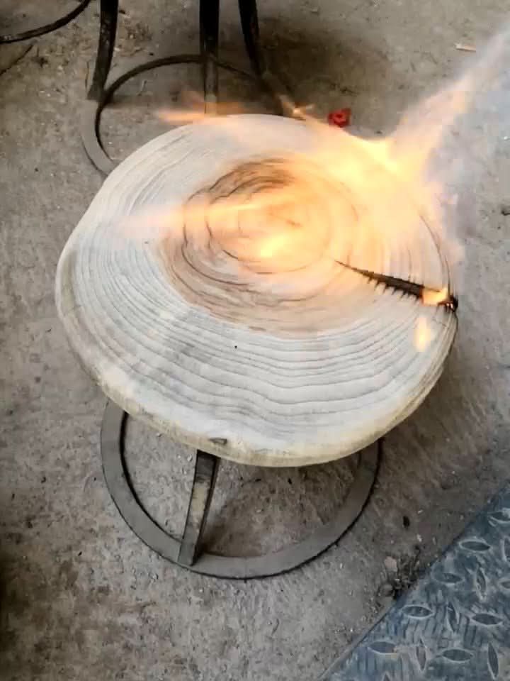 Wood stools with charred top being torched. Natural wood grain, metal base, home decor.