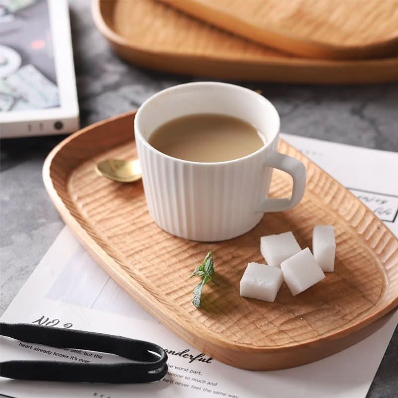 Carved wooden coffee tray with white mug, sugar cubes, and gold spoon. Farmhouse rustic decor.