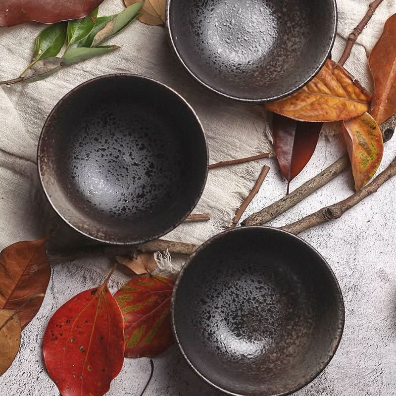 Rustic black ceramic 3 bowl set with speckled finish, styled with autumn leaves and branches.