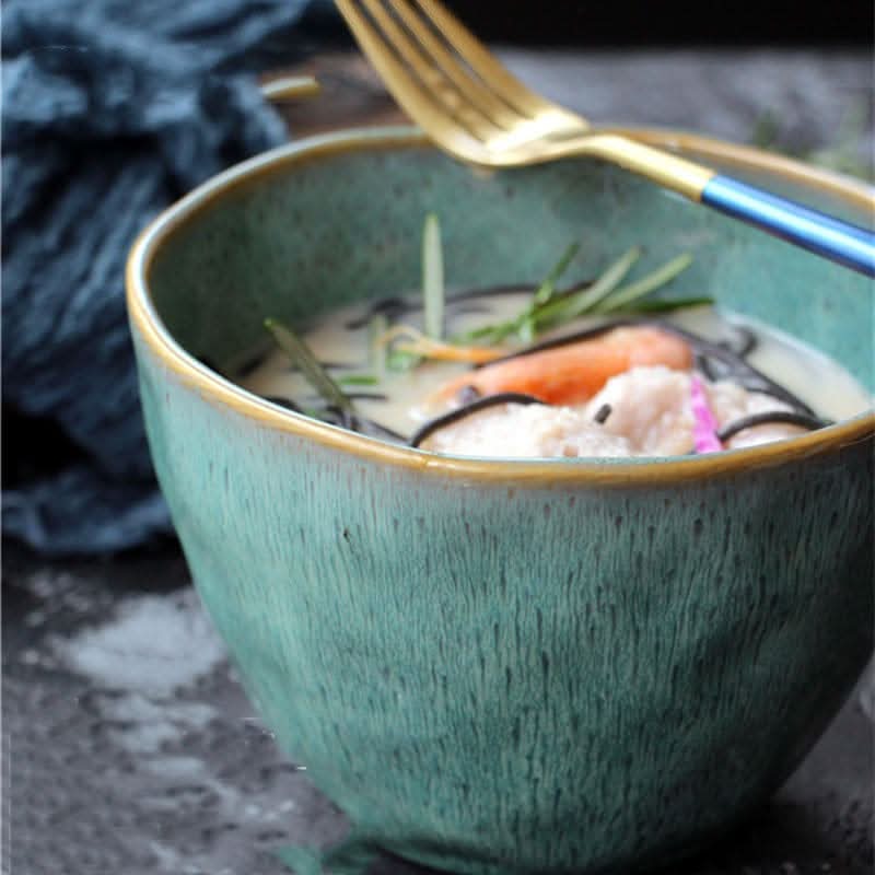 Ceramic blue glazed 5.9" bowl filled with soup and noodles, featuring a gold fork.