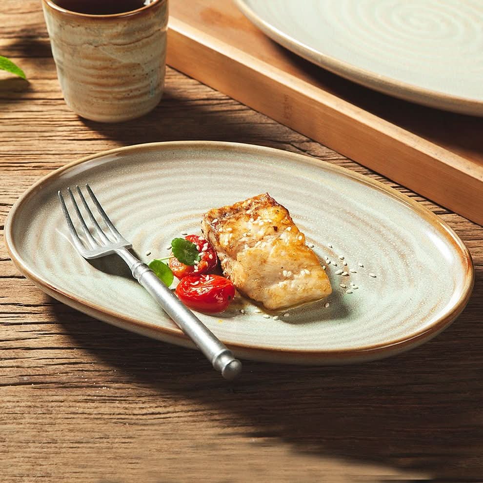 Grey retro stoneware oval plate with fish and tomatoes, part of a Japanese diner set.