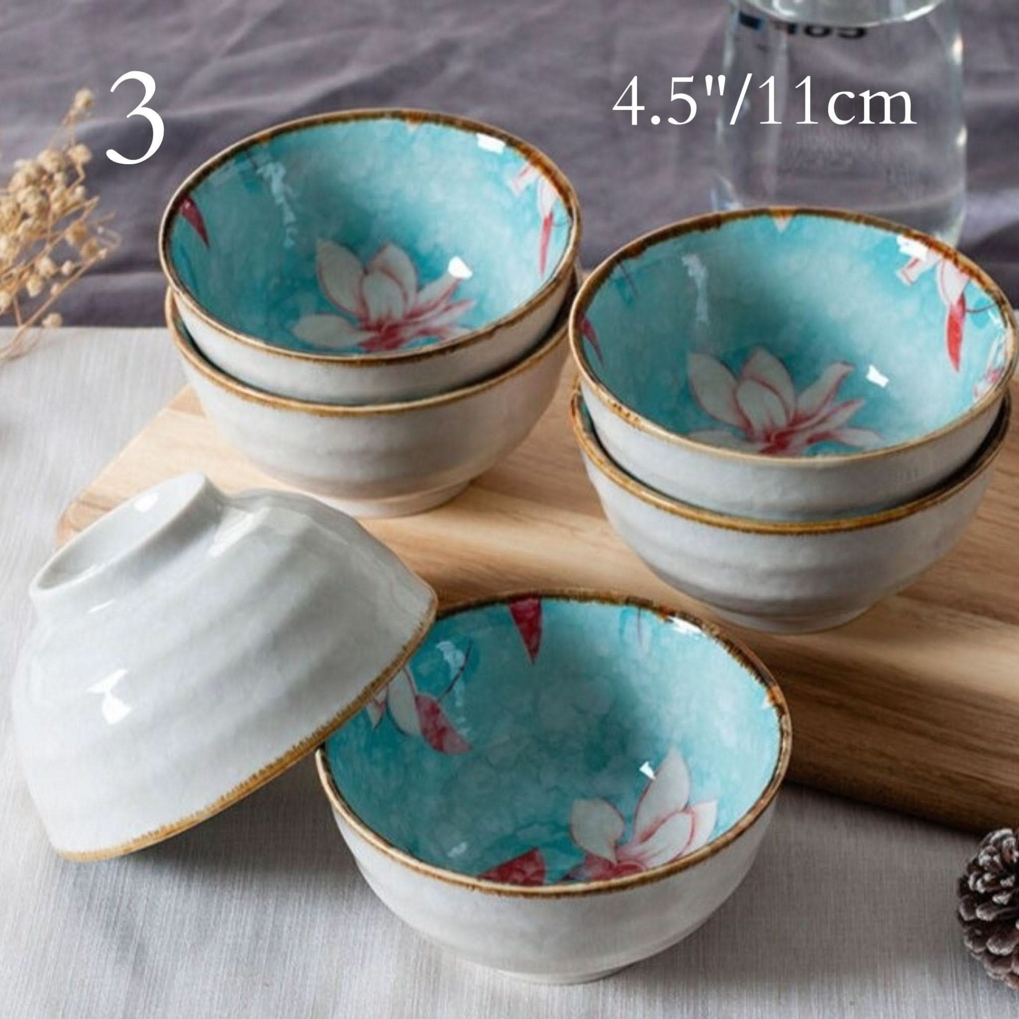 Ceramic glazed 4.5" bowls with Japanese lotus illustrations. Aqua blue interior.