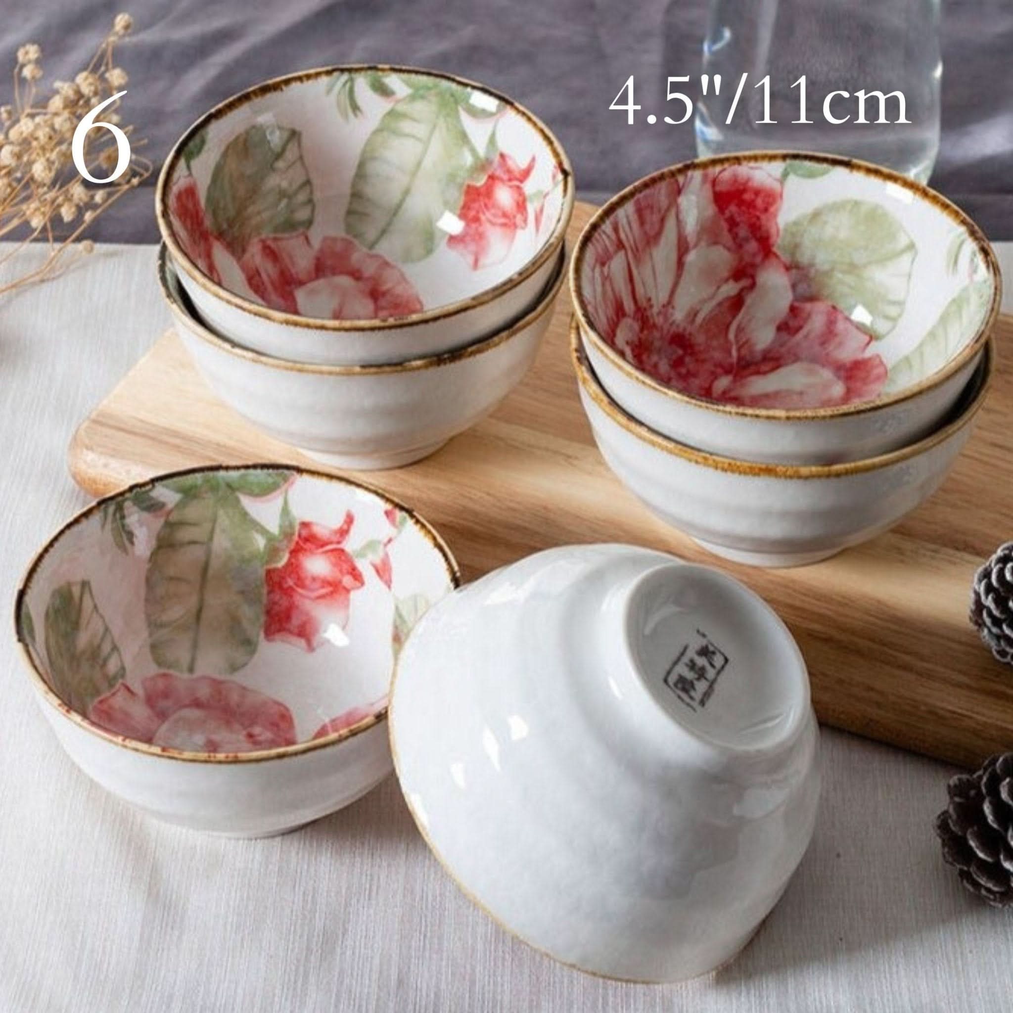 Ceramic glazed 4.5" bowls with Japanese floral illustrations on a wooden board.