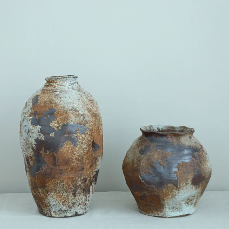 Ceramic Irregular Vase with rough, metallic texture in brown and white tones.