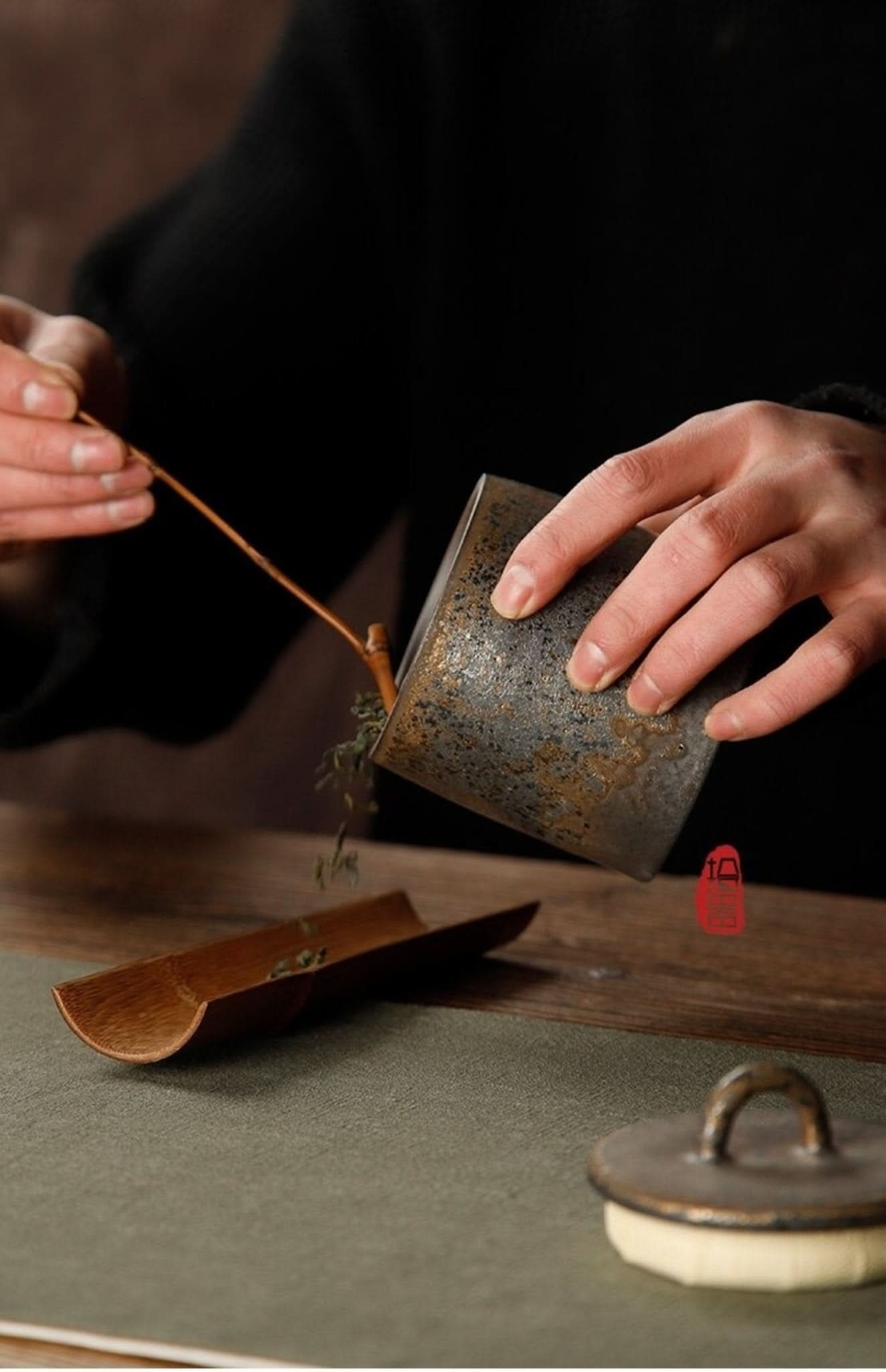 Rustic ceramic tea canister with distressed finish, tea ceremony in progress.