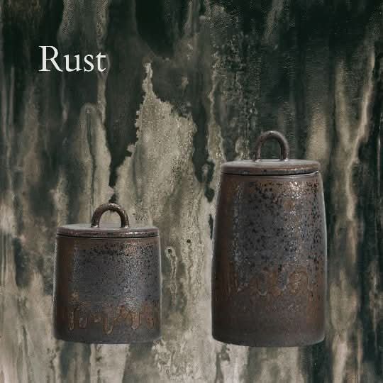 Two rustic ceramic tea canisters with speckled rust glaze, perfect for home decor.