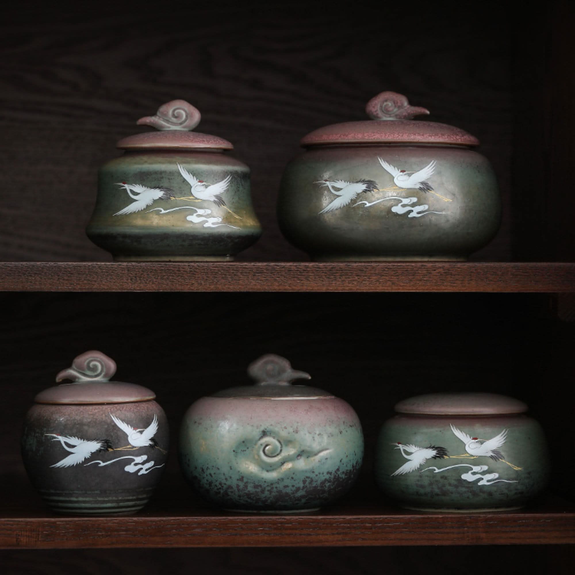 Ceramic tea can with Japanese crane illustration, green and brown hues, in a kitchen setting.