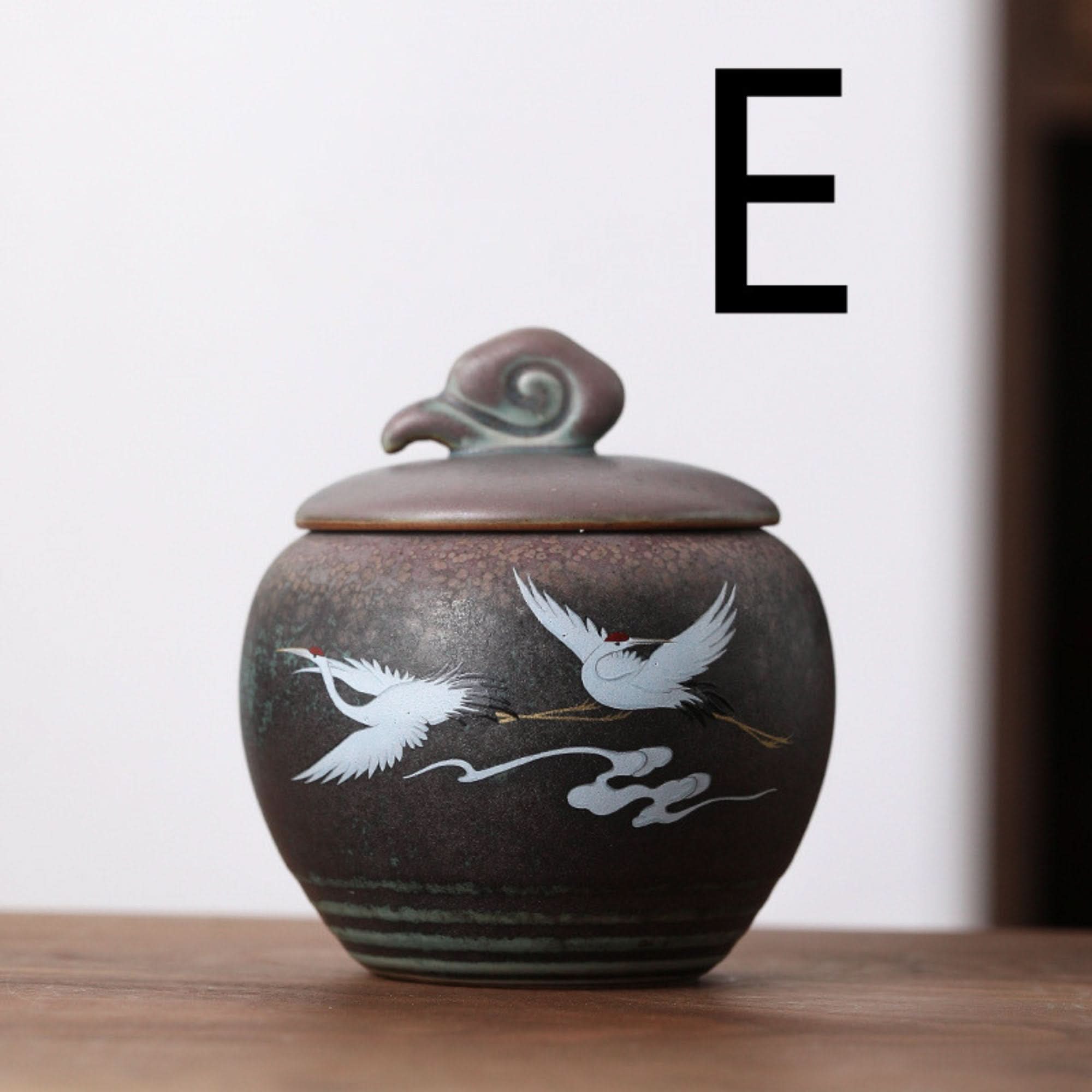 Dark ceramic tea can with Japanese crane illustration, for storage and kitchen organization.