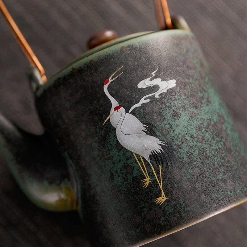 Ceramic tea pot with Japanese style crane design, dark green speckled finish.
