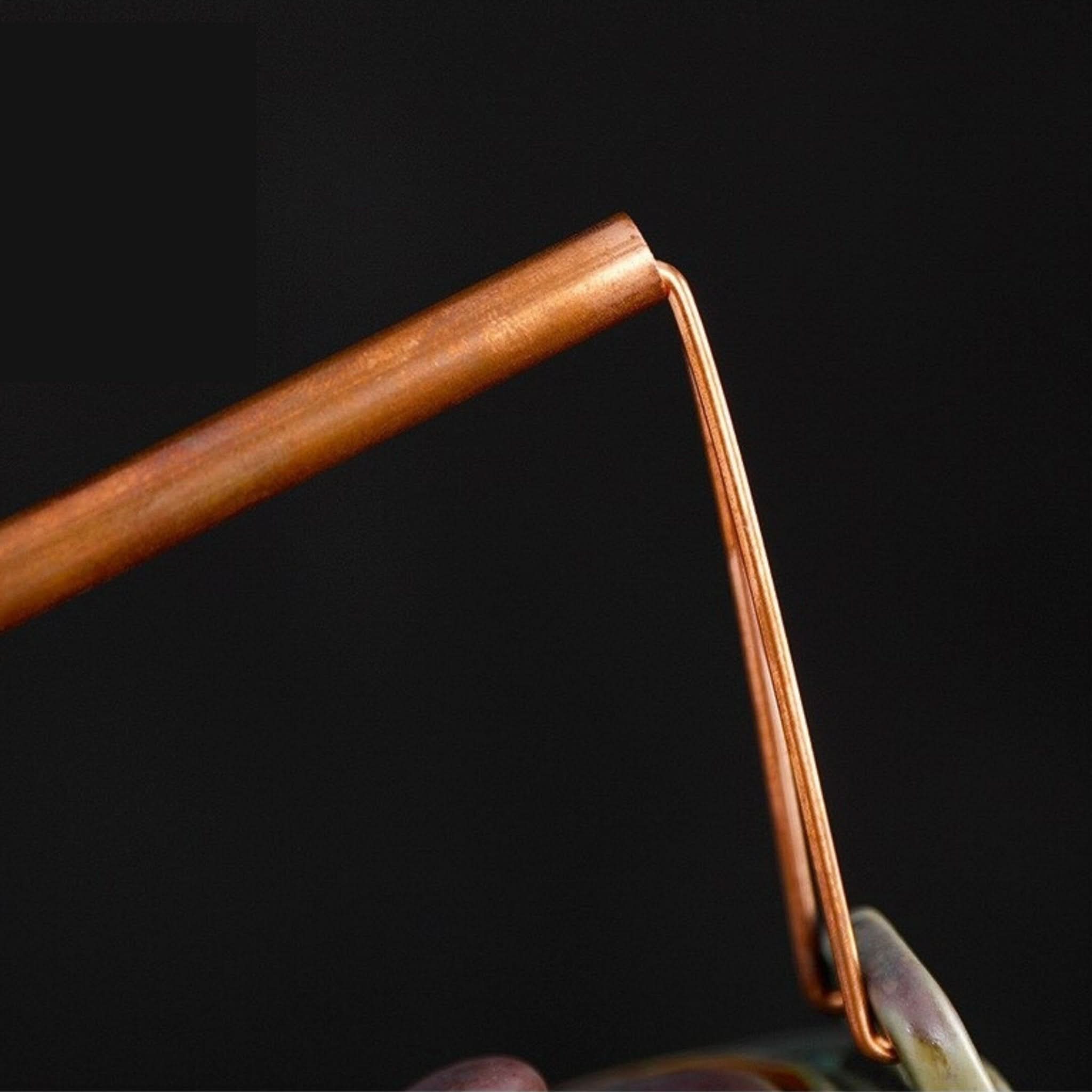 Copper handle detail on Japanese style crane ceramic tea pot.