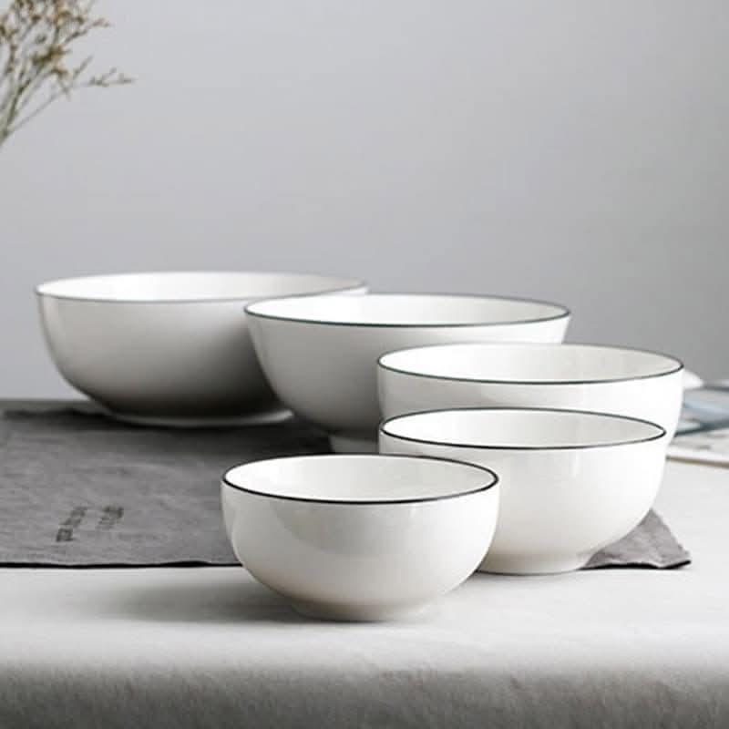 Set of 4 Japanese ceramic white bowls with black edges on a neutral surface.