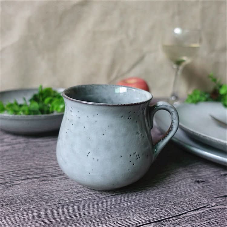 Cyan Blue Glazed Ceramic Dinnerware Set with Speckles, a mug on a wooden table setting with salad & wine.