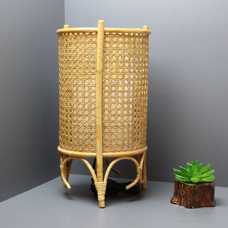 Cylindric Rattan Table Lampshade with 3 Legs, handwoven natural rattan on a grey surface.