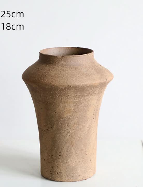 Cylindrical curved clay brown vase with rustic texture on a white background.