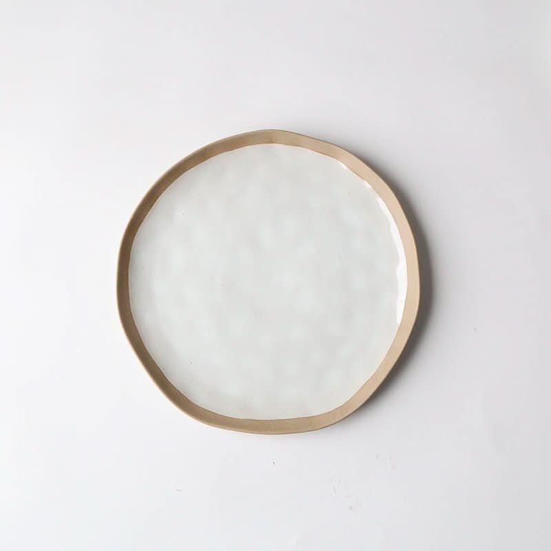 Irregular clay Japanese dinner plate with white glaze and tan rim, 20.2cm.