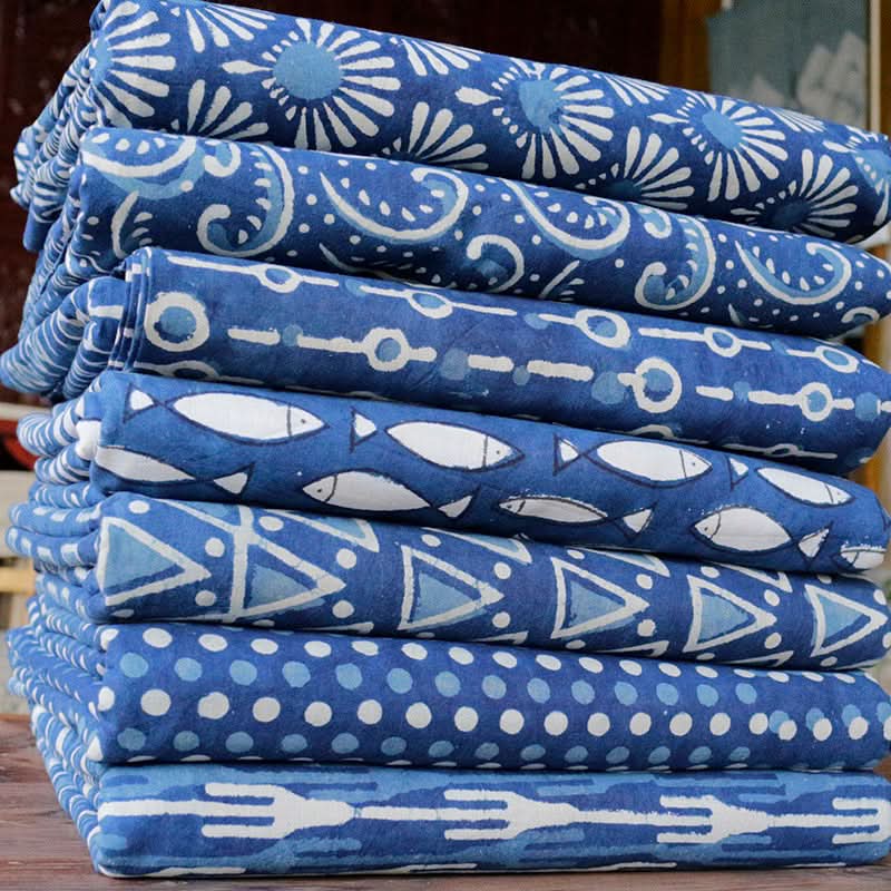 Blue dyed Indian fabric, pure cotton, with patterns like fish, dots, and abstract designs.