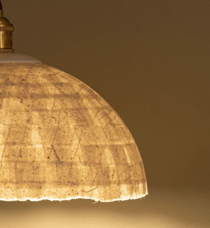 Natural paper mache lamp shade with textured, rustic finish and warm glow.