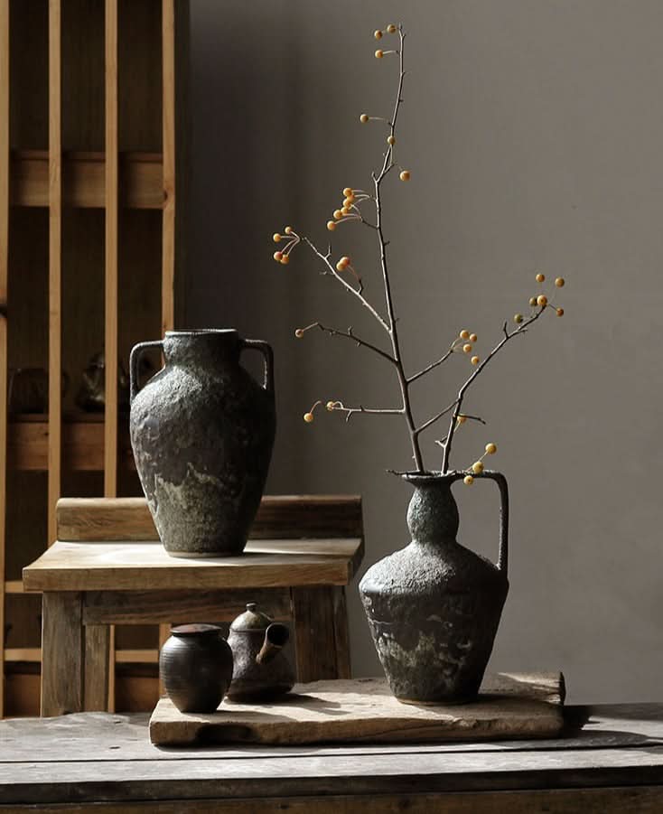 Wabi-sabi small ceramic vase with rustic texture, adorned with dried branches and berries.