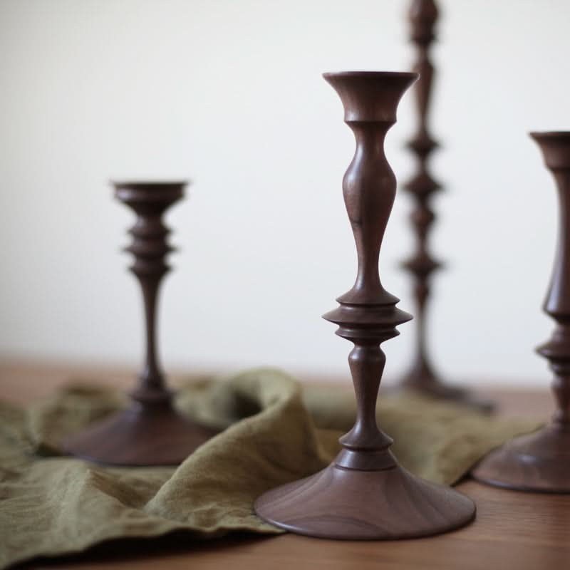 Wooden pillar candle holders made of walnut on a green cloth.