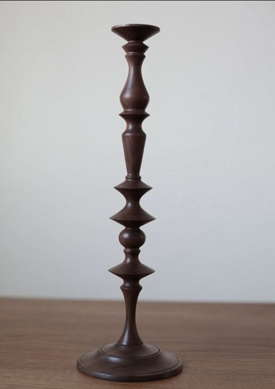Dark walnut wood pillar candle holder with tiered design, elegant home decor accent.