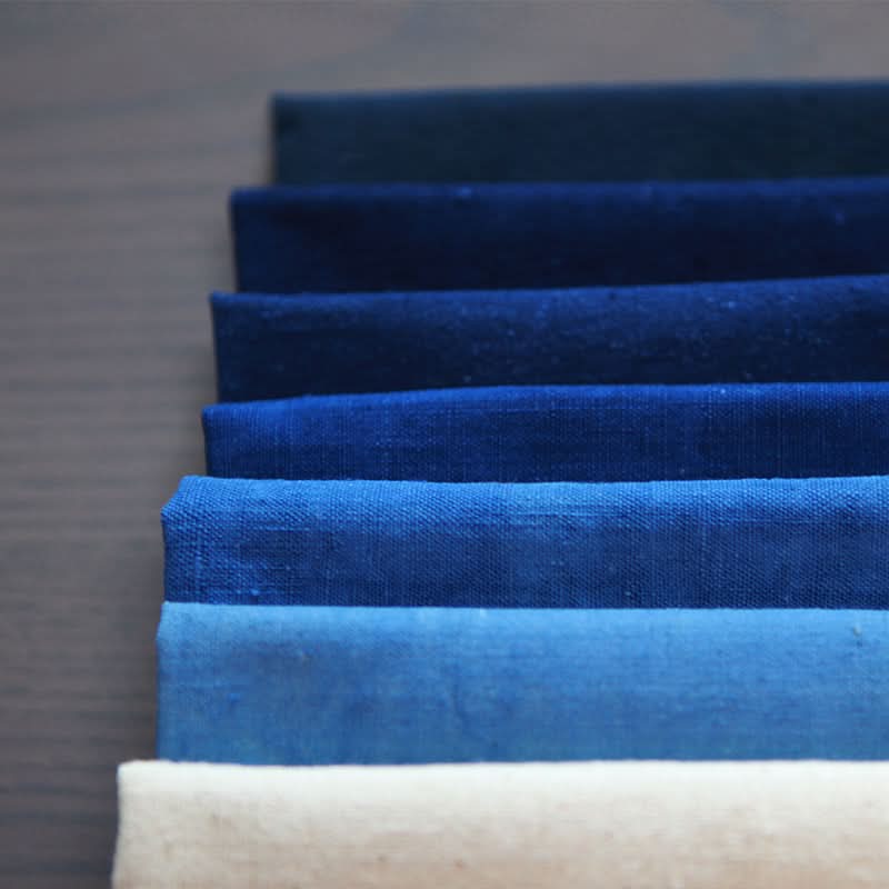 Stack of pure handmade Native Cotton Fabric in blue-grey plant-dyed tones.