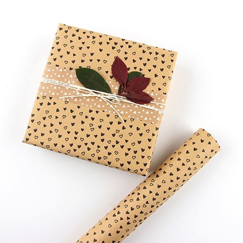 Brown gift paper with black hearts, tied with twine and decorative leaves.