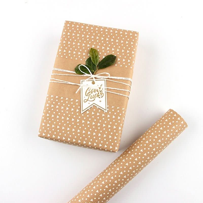 Brown geometric pattern gift paper roll with a wrapped gift featuring a "Good Luck" tag.