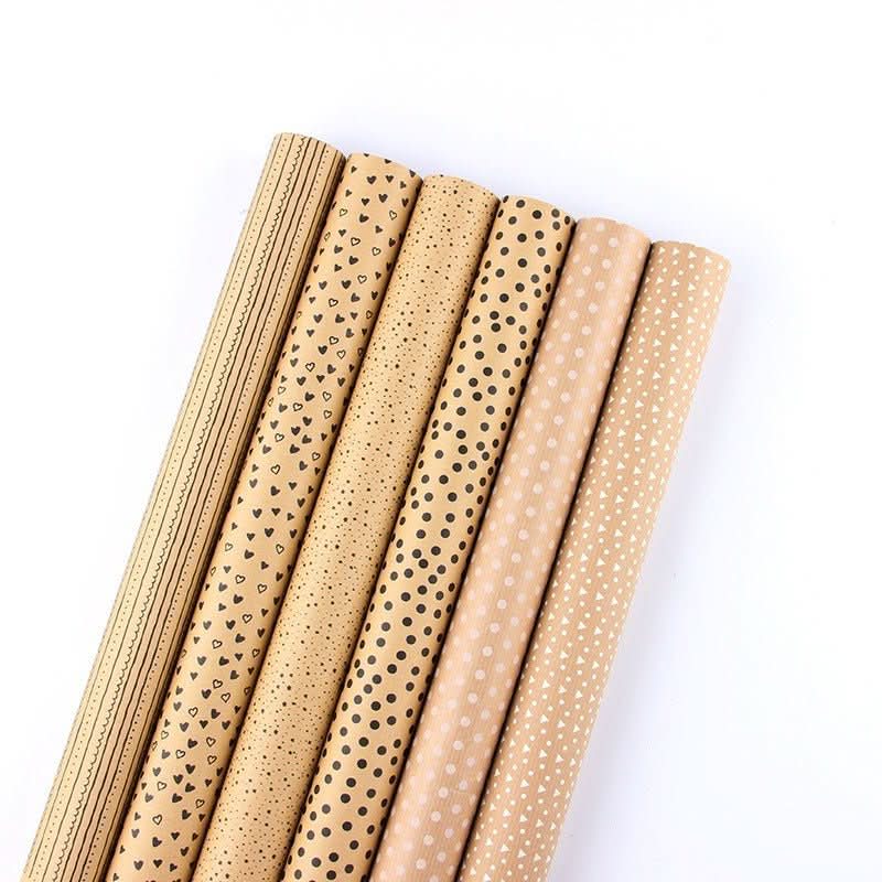 Kraft gift paper rolls with black and white heart, dot, and stripe patterns.