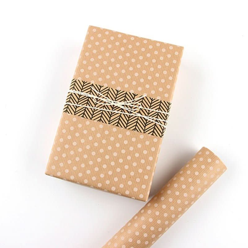 Brown polka dot gift paper roll with patterned band and twine, perfect for home decor.