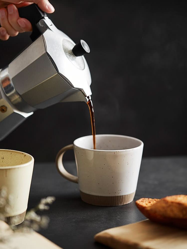 Cream speckled Glazed Clay Mug being filled with coffee. Handmade Nordic ceramic latte mug.