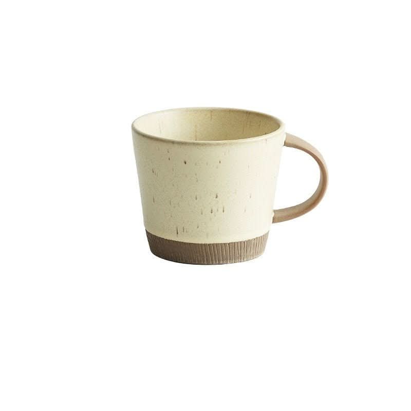 Cream speckled glazed clay mug with brown ribbed base. Handmade ceramic Nordic latte mug.